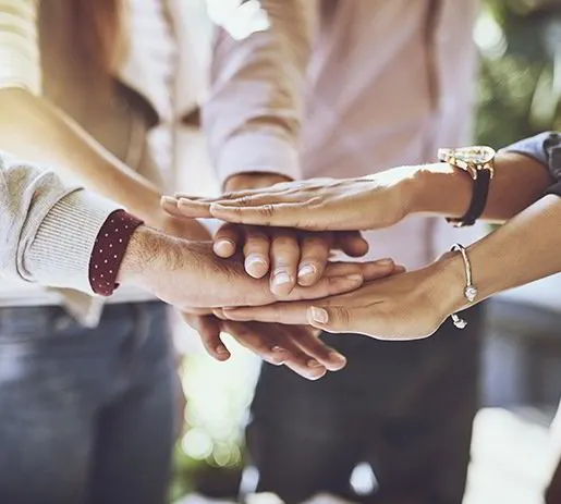 Team members joining hands in unity and support